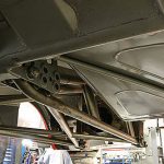 This view under the truck shows the swing arm rear suspension and a close look at the adjustable forward mount points. The advantage to using a swing arm-type suspension over the more traditional four-link is that it distributes power to both rear tires equally without transmitting any sort of torsional or twisting motion to the axle. This eliminates torque steer - a very real concern given the power levels expected from the race-tuned Duramax - and helps the truck launch in a straight line. While many swing arm designs offer no means of adjustability, this particular swing arm has six different forward mount points: three different pivot points on two levels. This design allows the suspension to be tuned for different track conditions.