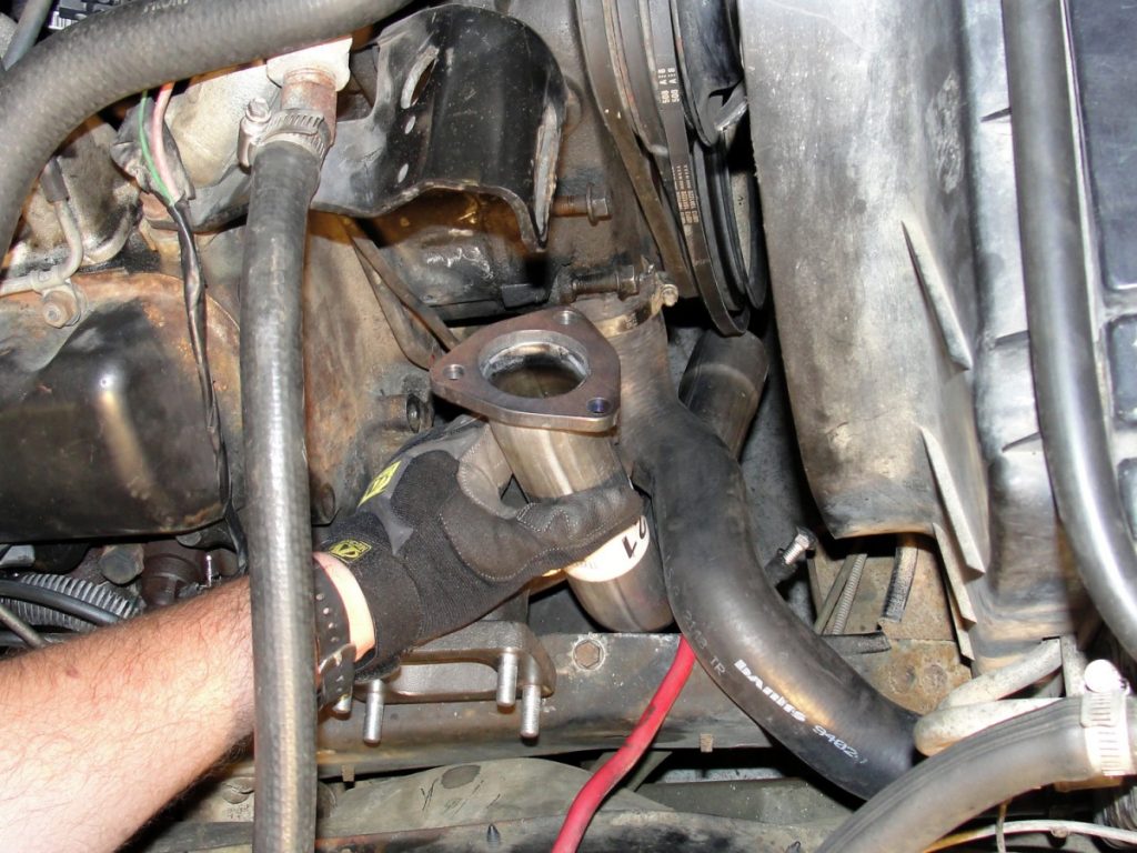 The new exhaust cross-over pipe is dropped into position and the new head pipe is positioned between the engine end the right frame rail.
