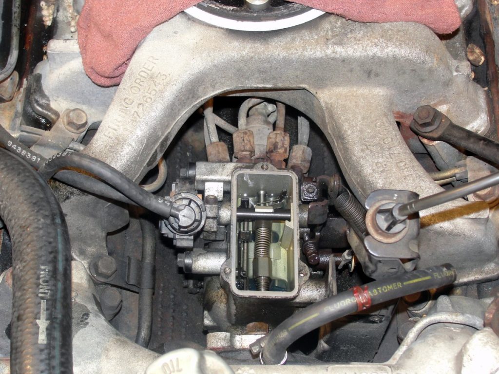 Disassembly begins by disconnecting the batteries, removing the air cleaner, air cleaner brackets, mounting studs, inlet gasket, and the crankcase vent tube assembly. After covering the intake opening with a clean rag and cleaning the area surrounding the injection pump and pump itself; the fuel rate must be turned up. This is accomplished by removing the top of the injection pump and locating an Allen head screw visible through an adjustment slot in the bottom of the pump.