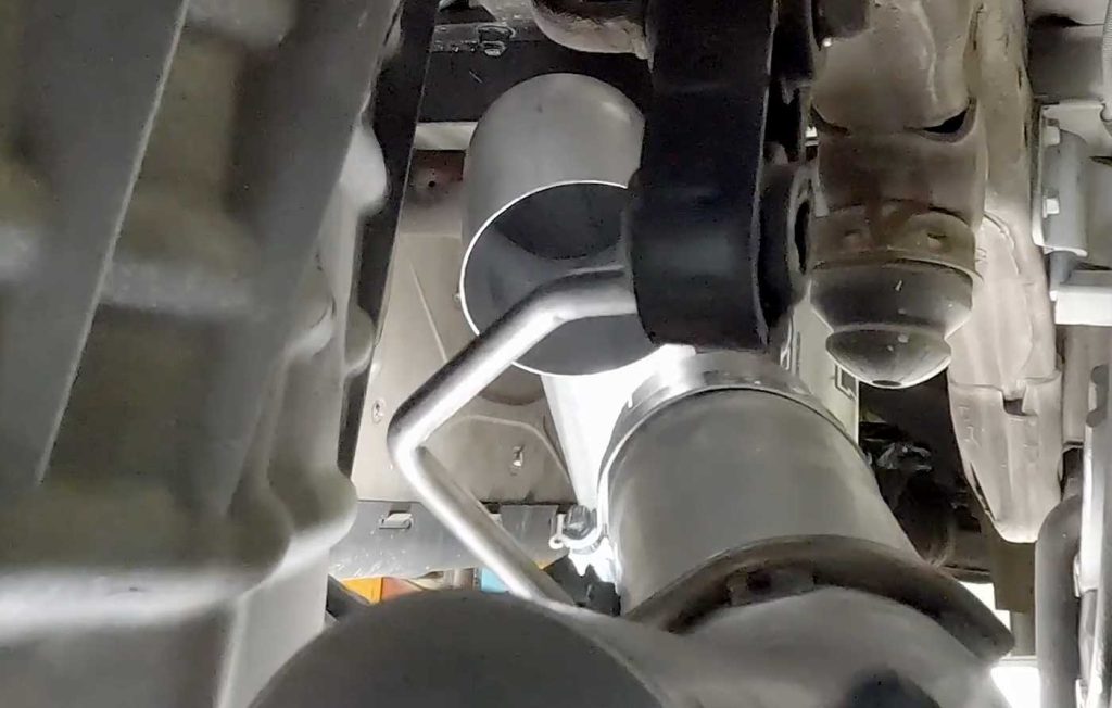 Raise the mid-tailpipe with the clamp to connect it to the front tailpipe. Attach it to the rubber hanger as you go by pushing it into the hanger pin.