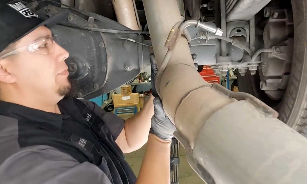 Once free, carefully guide the exhaust pipe down to where you can rest it.