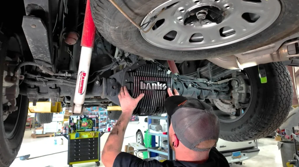 Technician installing Banks CoolRunner Oil Pan on a 2022 GMC Duramax